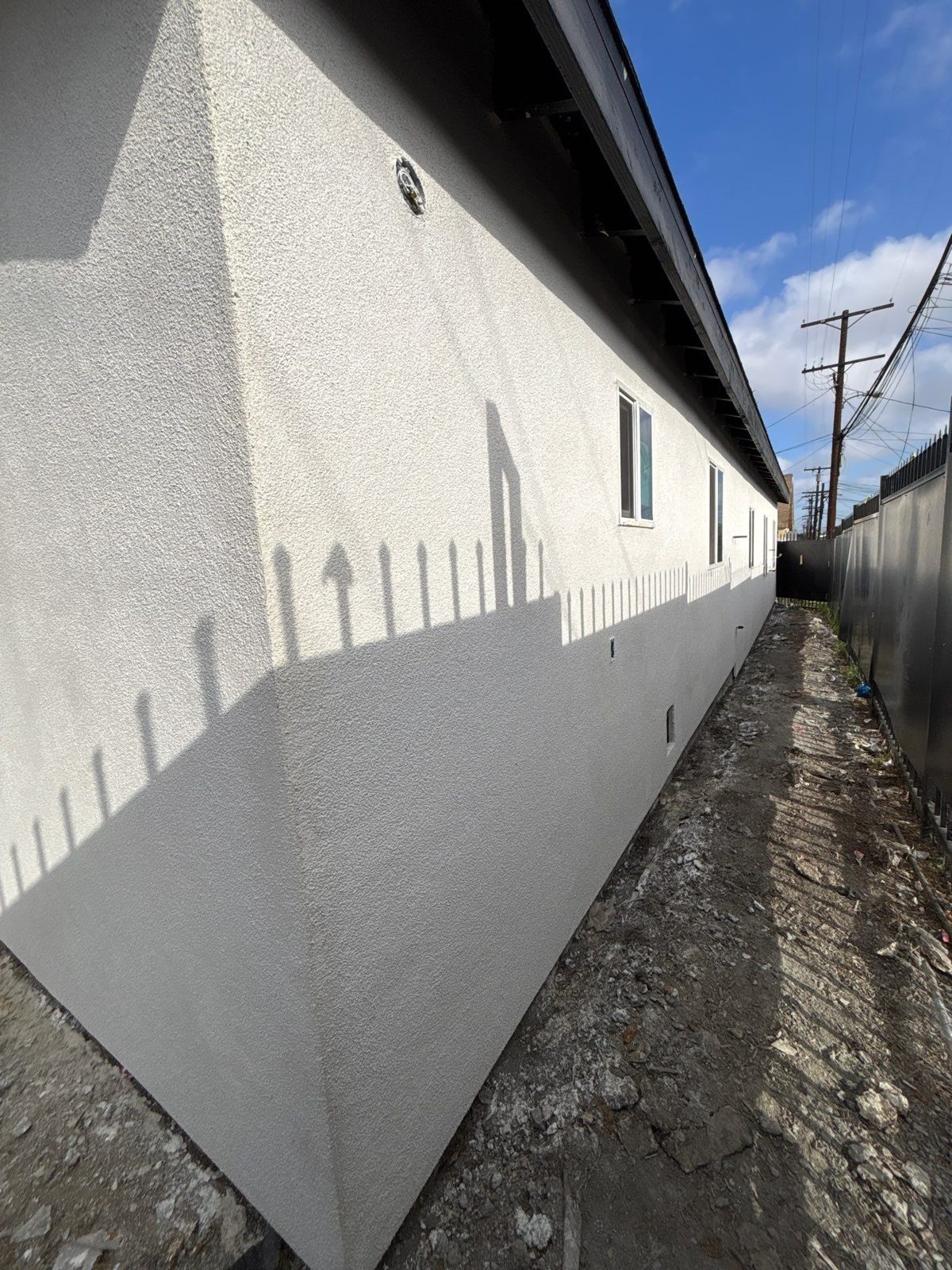 Finished stucco along the full side wall of a house