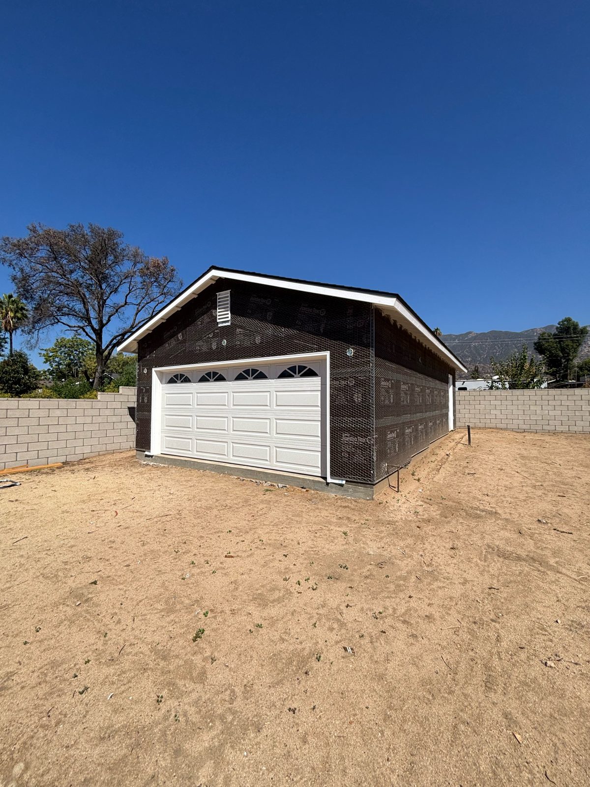 Detached garage wrapped in paper and wire mesh before stucco