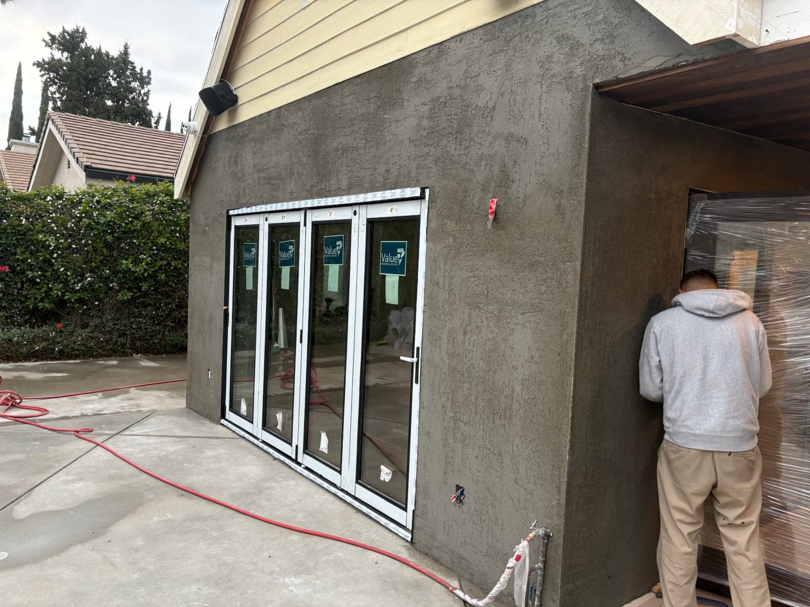Brown coat stucco going on around new sliding glass doors